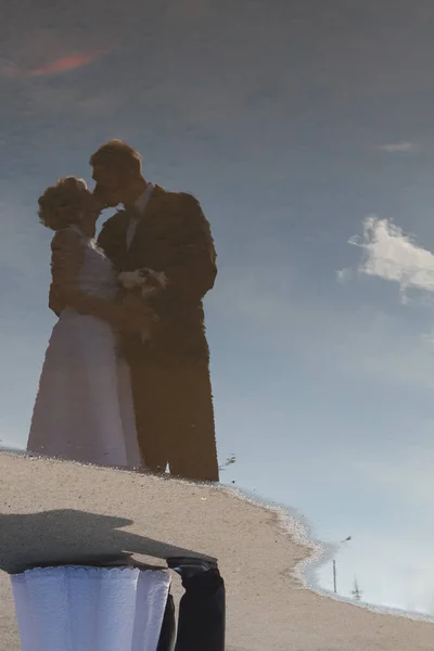 Hochzeitspaar spiegelt sich in Wasserpfütze — Stockfoto