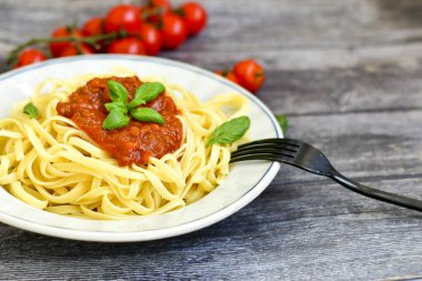 İtalyan usulü spagetti bolonez. Domates soslu taze bucatini makarna, fesleğen, otlar, parmesan peyniri, taze vişneli domates ve ahşap zemin üzerinde maydanoz. Mutfak Posteri 