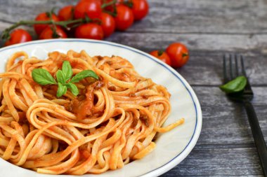 İtalyan usulü spagetti bolonez. Domates soslu taze bucatini makarna, fesleğen, otlar, parmesan peyniri, taze vişneli domates ve ahşap zemin üzerinde maydanoz. Mutfak Posteri 