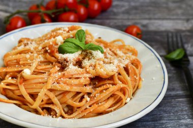 İtalyan usulü spagetti bolonez. Domates soslu taze bucatini makarna, fesleğen, otlar, parmesan peyniri, taze vişneli domates ve ahşap zemin üzerinde maydanoz. Mutfak Posteri 