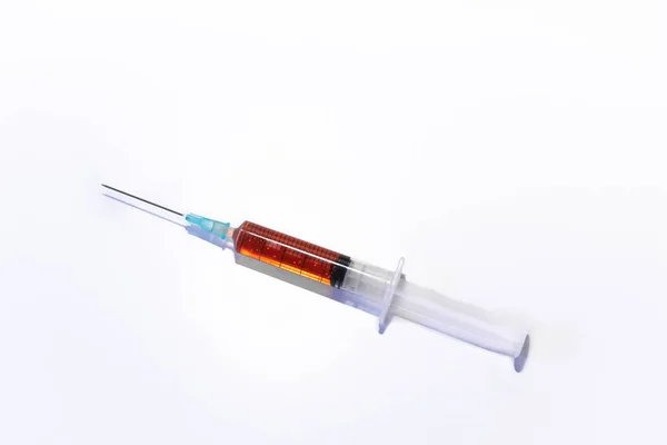 Injectiespuit Naald Met Oranje Vaccin Diagonaal Een Tafel Een Witte — Stockfoto