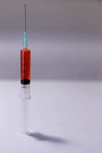 Injectiespuit Naald Met Oranje Vaccin Diagonaal Een Tafel Een Witte — Stockfoto