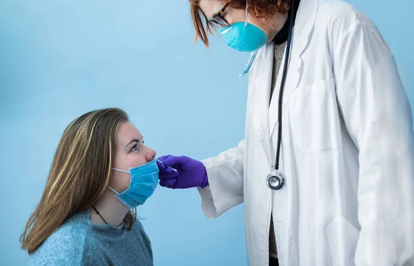 female doctor with mask doing covid-19 test on a young blonde girl