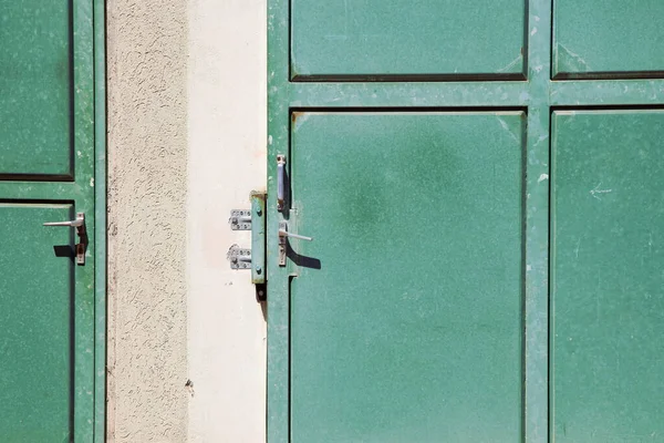 two green blank metal doors, sliding security door, steel doors and concrete surrounding. closed door theme and copy space