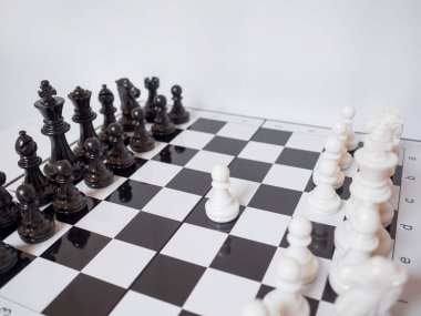 Siyah ve beyaz satranç ordusu beyaz arkaplanlı bir tahtanın üzerinde duruyor. Başarılı bir iş stratejisi planlamakta güçlük çekiyorlar.