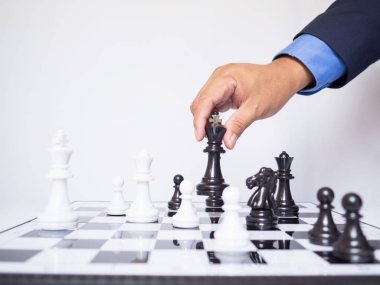 Beyaz arkaplanlı satranç taşını taşıyan iş adamı el çabukluğu, başarı konseptine iş stratejisi planlamakta zorlanıyor