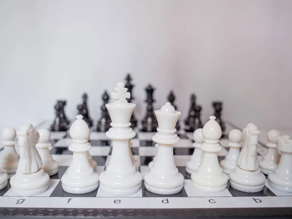 Zwart-wit schaakleger staan op een bord met witte achtergrond, uitdagingen plannen business strategie om succes concept — Stockfoto