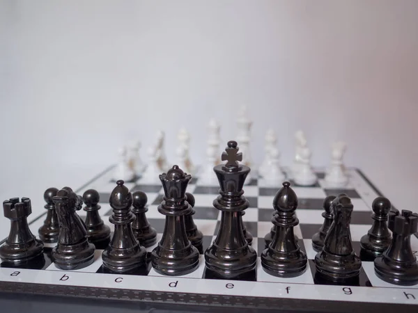 Black and white chess-Army are standing on a board with white background, challenges planning business strategy to success concept
