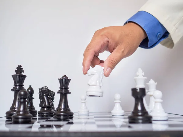 Empresario mano moviendo pieza de ajedrez rey a bordo con fondo blanco, desafía la planificación de la estrategia de negocio al concepto de éxito — Foto de Stock