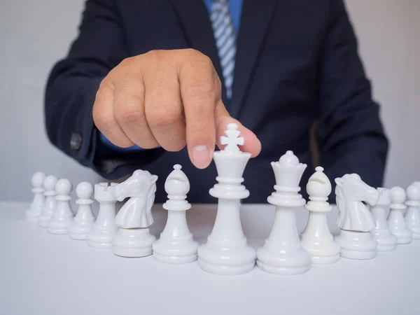 Бізнесмен рука рухає шахову фігуру на борту з білим тлом, виклики планування бізнес-стратегії до концепції успіху — стокове фото