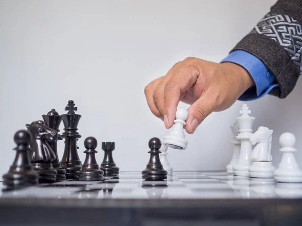 Бізнесмен рука рухає шахову фігуру на борту з білим тлом, виклики планування бізнес-стратегії до концепції успіху — стокове фото