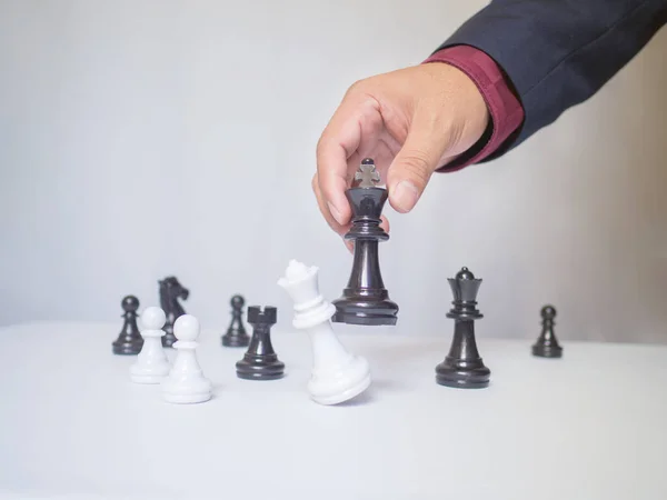 Beyaz arkaplanlı satranç taşını taşıyan işadamı, iş stratejisini başarı konseptine taşımakta zorlanıyor — Stok fotoğraf
