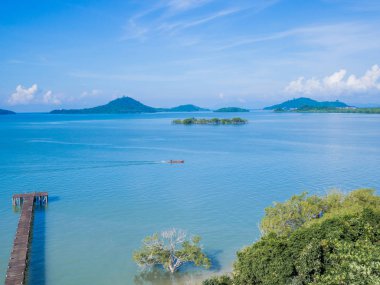 Mavi denizde ve gökyüzünde güzel gün ışığında bir ada
