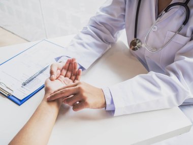 Doktor hastanın nabzını elle kontrol eder ve sonuçları kaydeder.
