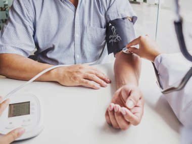 Doktor steteskopla hastayı muayene eder ve sonuçları kaydeder.