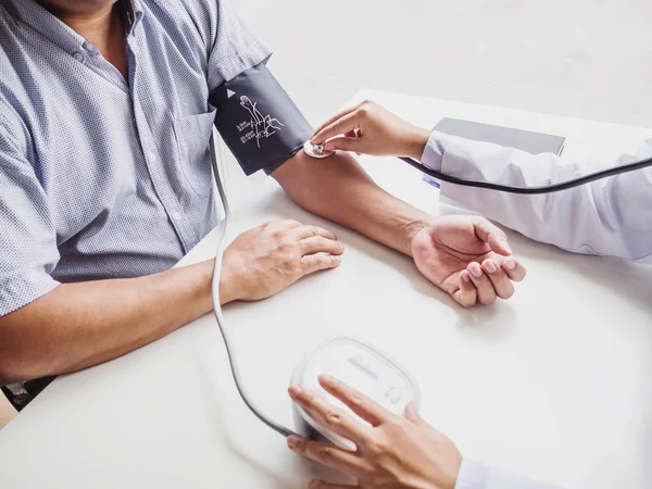 El médico evalúa al paciente con un estetoscopio y registra los resultados — Foto de Stock