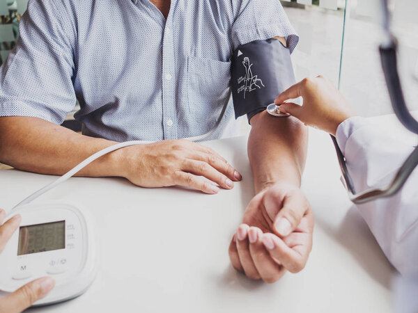 Врач оценивает пациента со стетоскопом и записывает результаты
