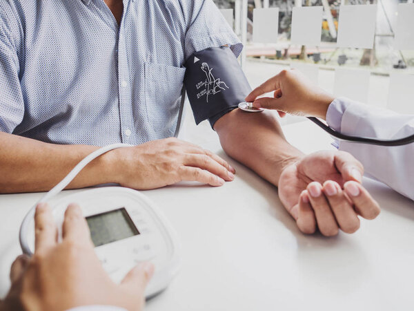 Врач оценивает пациента со стетоскопом и записывает результаты
