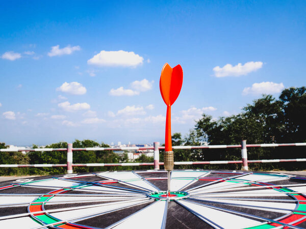Dart Board Isolated on blue sky and city view background, Setting challenging business goals And ready to achieve the goal concept