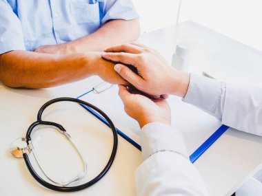 Doktor cesaret vermek için el ele tutuştu ve sağlık muayenesi sonuçlarını hastaya açıkladı.