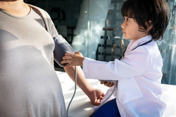 Der Kinderarzt begutachtet den Patienten mit Stethoskop, Blutdruckmessgerät — Stockfoto
