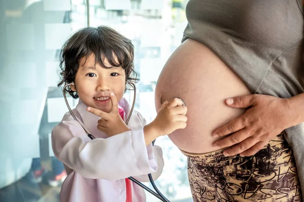 Фото детского врача и стетоскопа с беременной матерью в — стоковое фото