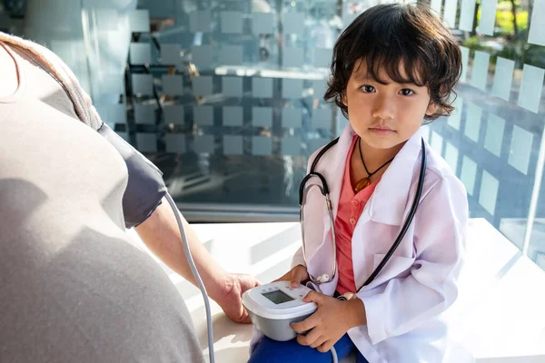 Le médecin de l'enfant évalue le patient avec un stéthoscope, un tensiomètre — Photo