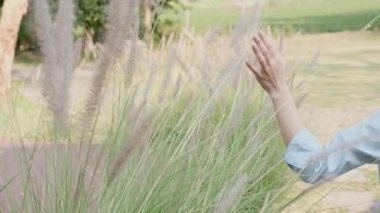 Kadın çimenlere dokunmak için elleriyle yürüdü..