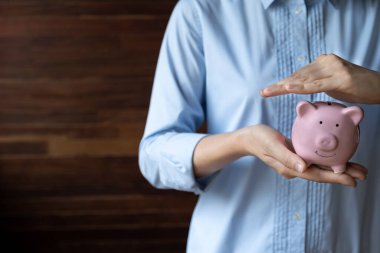 İş kadını, mavi kumbaraya para koyup yeni iş hedefi ve emeklilik konsepti için para biriktiriyor..