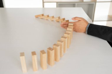Kadın diğer tahta blokları korumak için ahşap blokları elle durdurur yönetim ve strateji planı riskini kavrar..