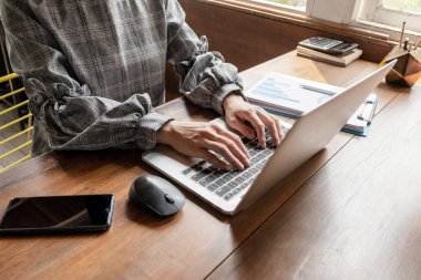 İş kadını evde dizüstü bilgisayarı ve telefonuyla çalışıyor..