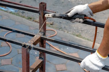 Tamirci çeliği kaynaklamak için kaynak makinesi kullanıyor..