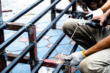 Tamirci çeliği kaynaklamak için kaynak makinesi kullanıyor..