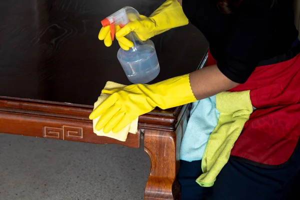 The housekeepers  used cloth and cleaning solution to clean the table and chair.