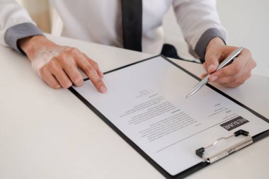 Ofis yöneticisi toplantı odasında başvuranın özgeçmişini okuyor..