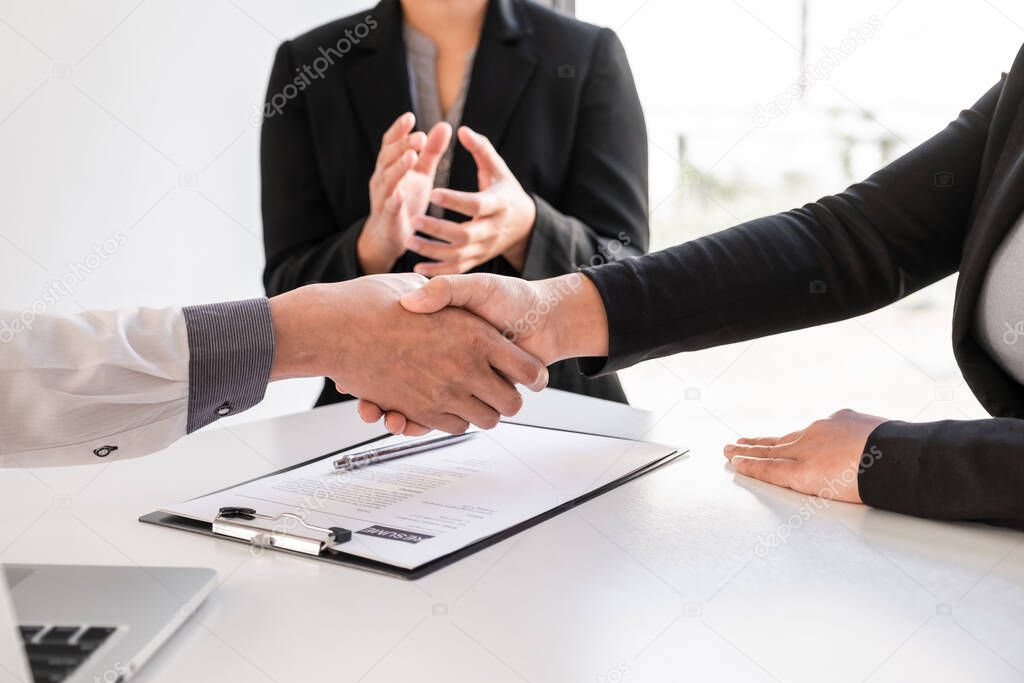 Shaking hands and clap after office executives are interviewing job applicants in the meeting room.