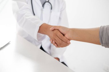 Doktorlar ve hastalar sağlık muayenesinin sonuçlarını öğrendikten sonra el sıkışıyorlar..