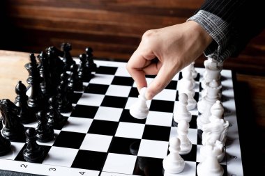 İş kadınları beyaz arka planda satranç oynuyor, iş stratejisini başarı konseptine taşımakta zorlanıyor.