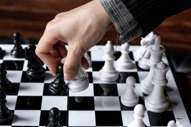 İş kadınları beyaz arka planda satranç oynuyor, iş stratejisini başarı konseptine taşımakta zorlanıyor.