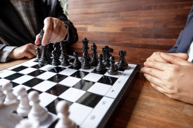 İş kadınları beyaz arka planda satranç oynuyor, iş stratejisini başarı konseptine taşımakta zorlanıyor.