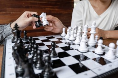 İş kadınları beyaz arka planda satranç oynuyor, iş stratejisini başarı konseptine taşımakta zorlanıyor.