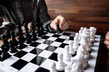 İş kadınları beyaz arka planda satranç oynuyor, iş stratejisini başarı konseptine taşımakta zorlanıyor.