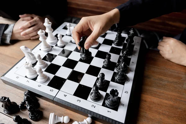 Business women play chess on board with white background, challenges planning business strategy to success concept.