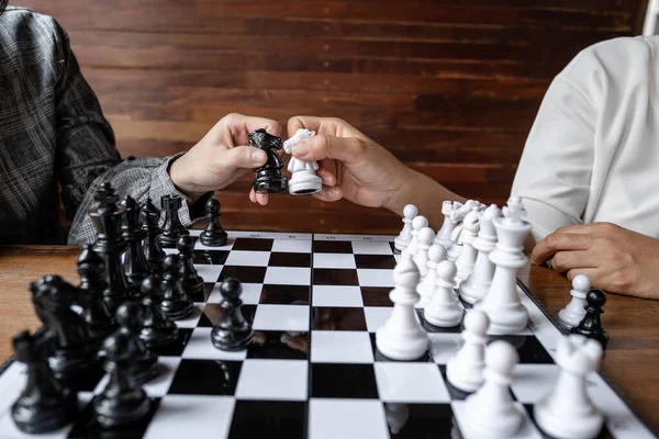 Business women play chess on board with white background, challenges planning business strategy to success concept.