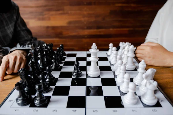 Business women play chess on board with white background, challenges planning business strategy to success concept.