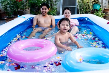 Mutlu aile yazın şişme havuzda yüzüyor..