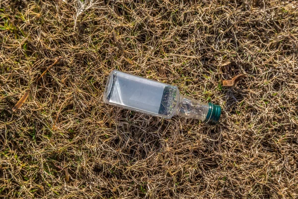 Small liquor bottle lying on the ground — Stockfoto
