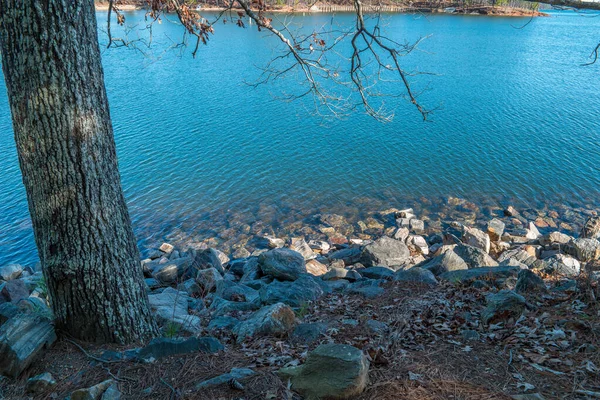 Oever van het meer met stenen — Stockfoto