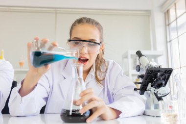 Güzel bir kadın bilim adamı laboratuvarda çeşitli ekipmanlarla çalışıyor..