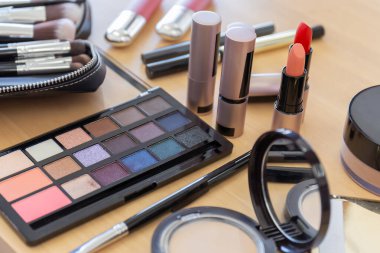 Tahta masada bir sürü makyaj malzemesi var.